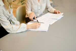 New employee signing onboarding paperwork with a manager