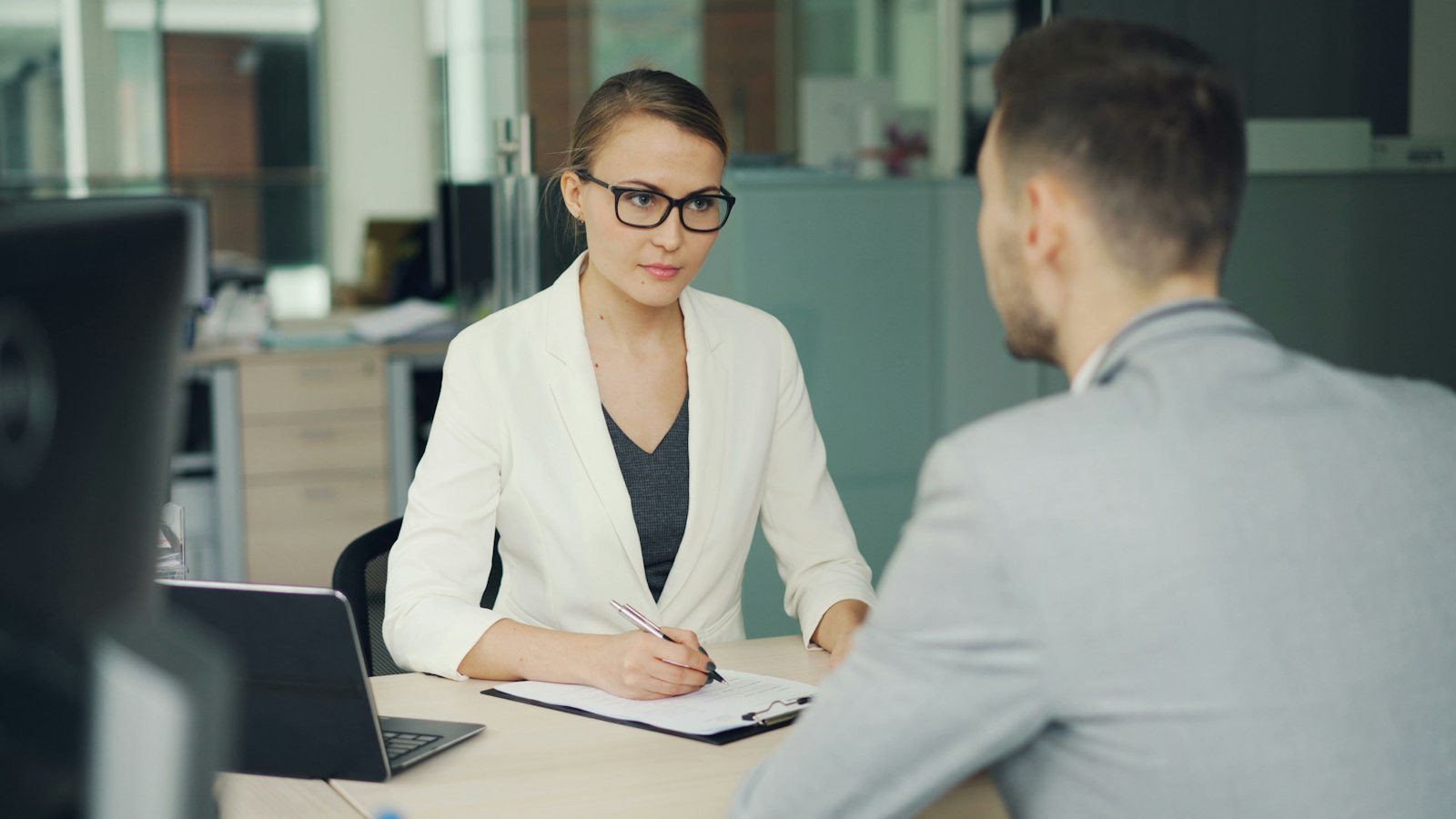 Manager meeting one-on-one with an employee at an office desk