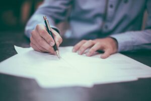 Employer completing employment verification paperwork at a desk