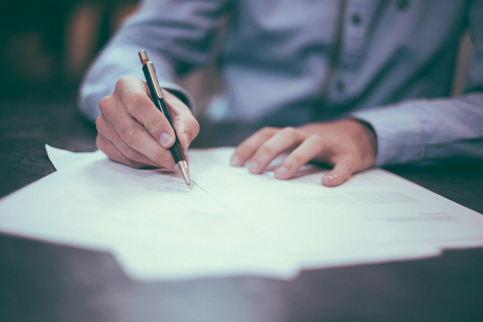Employer completing employment verification paperwork at a desk