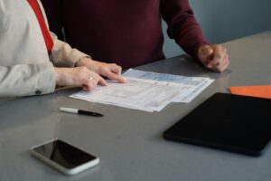 Two business professionals reviewing employment documents at a conference table