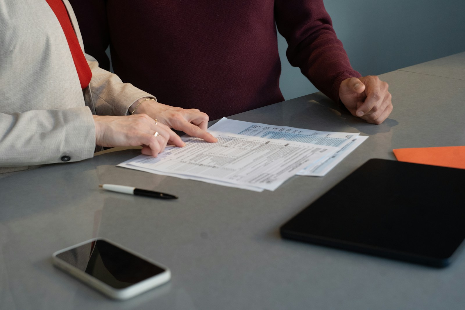 Two business professionals reviewing employment documents at a conference table